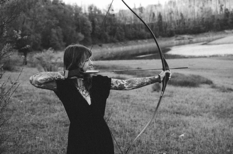 Angelina Katharina Petersen spannt konzentriert einen Bogen in der Natur – innere Klarheit und Achtsamkeit in Leipzig