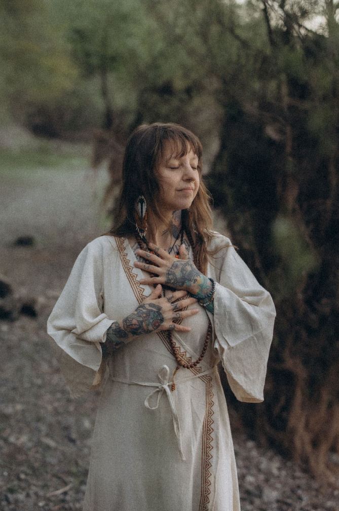 Angelina Katharina Petersen im Leinenkleid in der Natur, mit geschlossenen Augen, Hände auf der Brust – innere Ruhe finden, Achtsamkeit Leipzig
