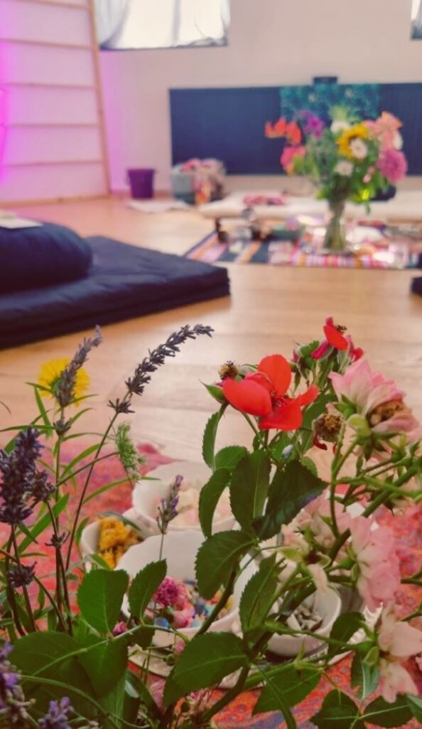 Angelina Katharina Petersen – liebevoll gestalteter Raum mit Blumen und Zeremoniedecke in Leipzig, Ort für innere Ruhe und Achtsamkeit