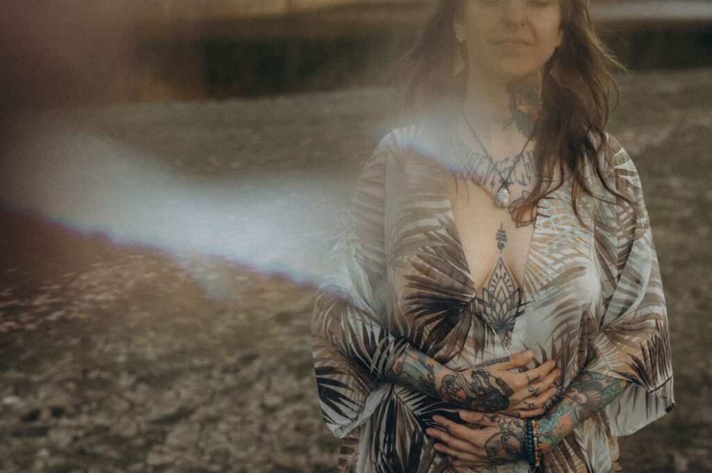 Angelina Katharina Petersen, sie steht in der Natur, ihre Hände liegen auf der Körpermitte, sie spürt sich und ihre Gefühle